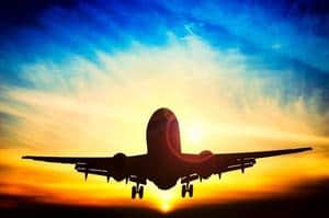 A plane taking off into the sunset