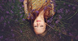 Girl lying on ground surrounded by lavender