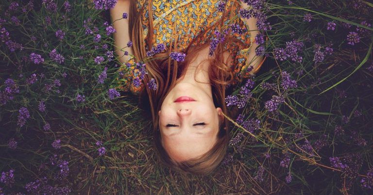 Girl lying on ground surrounded by lavender