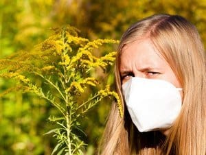 Girl with mask standing by goldenrod