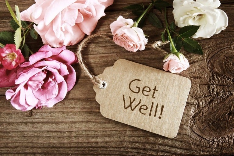 Tag that says "Get well" on wood with roses