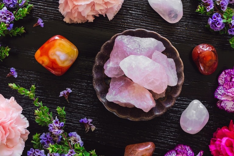 Rose Quartz and Carnelian on Dark Table with Carnations and Sea Lavender