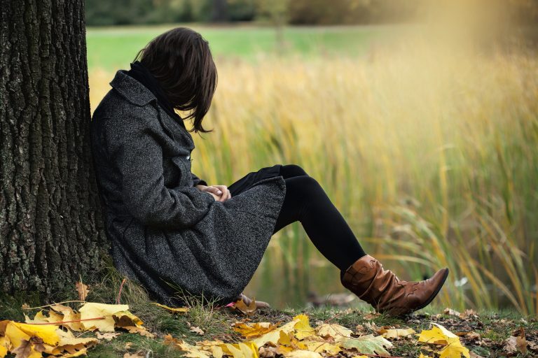 Woman contemplating alone in the autumn park