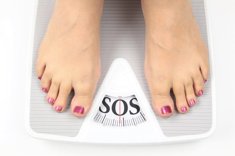 woman standing on a scale that reads SOS