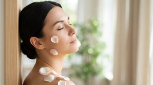 Woman's face in soft natural daylight with delicate flower petals — emotional roots of rosacea
